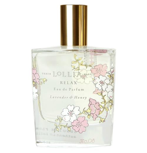 Clear perfume bottle with flowers on it and a gold lid.
