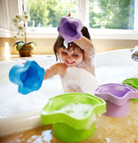 A little girl is shown playing with the star-shaped stacking cups in the bath tub.