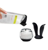 The container of sea salt pours into the clear ball of the "SaltBall" Salt Grinder. 