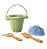 The Sand Play Set has a green bucket, a blue sand castle mold, a brown shovel, and a brown rake.