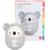 A picture of a toy koala in front and the package in the back. A toy gray, rosy-cheeked koala bear is shaped like an egg. The cartoonish eyes, nose, and mouth are all black. The package has the picture of the toy with a white background, with a red, pink, orange, yellow, green, light blue, and dark blue border.