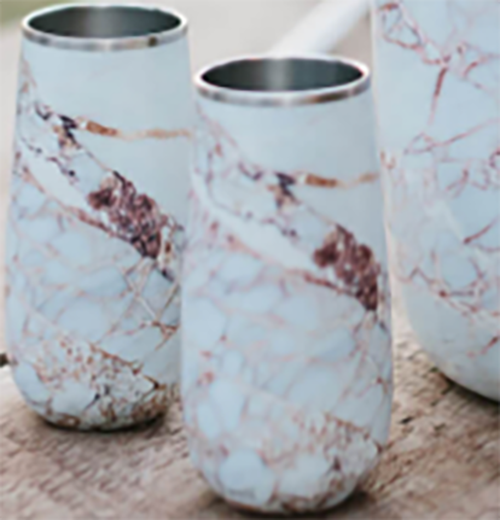 Two wine tumblers with a white marbled design on an outdoor table..