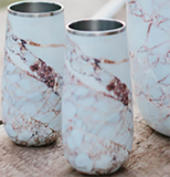 Two wine tumblers with a white marbled design on an outdoor table..