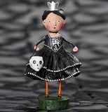 The black and white skeleton princess figurine holding a skull candy bucket is shown standing against a blurred black and white background.