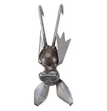 This metal sculpture is of a small bat with large ears and folded wings hanging from its feet.