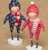 The blue and red outfitted snow suit figurines are shown standing together.