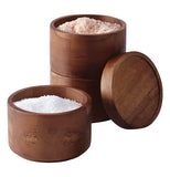 Set of 2 stacking round salt boxes showing seasonings inside the boxes.