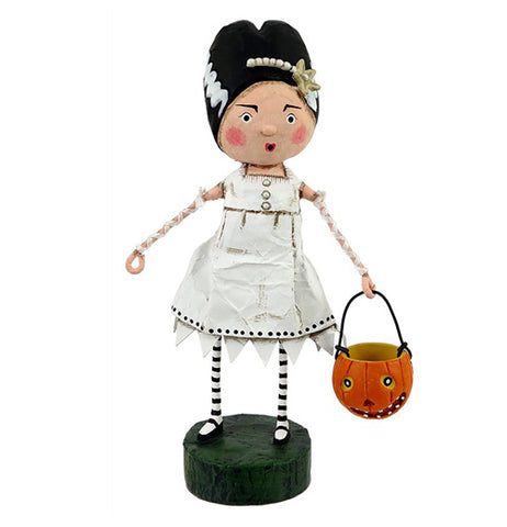 This figurine is of a woman wearing a bride of Frankenstein costume with a white ragged dress and is carrying a pumpkin shaped pail.