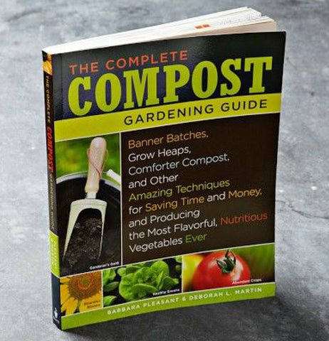 The compost gardening book is shown standing on a metal surface.