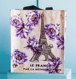 The Small "French Kiss" Tote Bag sits on a blue box against a blue background.