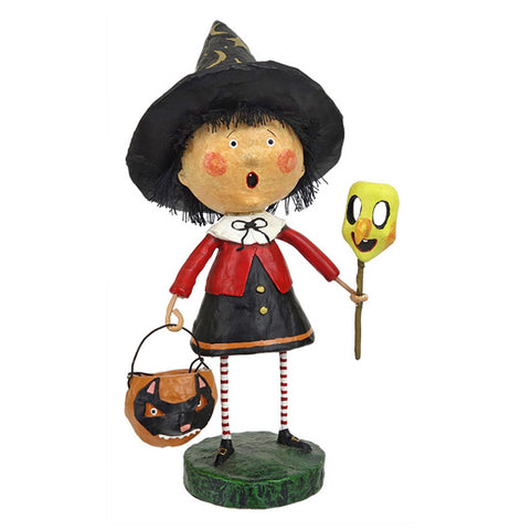 A little witch carrying a treat bucket and holding a mask