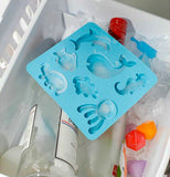 The blue ice tray with the different ocean animal stencils is shown with ice cubes.