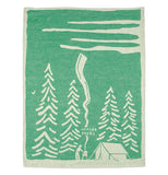 The green towel with white edges and the white barbecue and tree design is shown completely unfolded.
