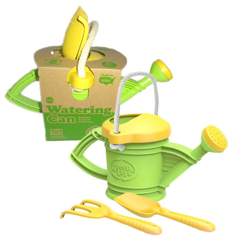 These green and yellow toy watering cans are shown with a yellow plastic rake and shovel. The watering can near the top of the image is shown in its cardboard packaging.