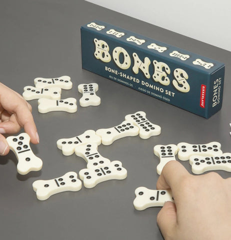 The black box is shown with its bone shaped dominoes put in a set for a dominoes game.