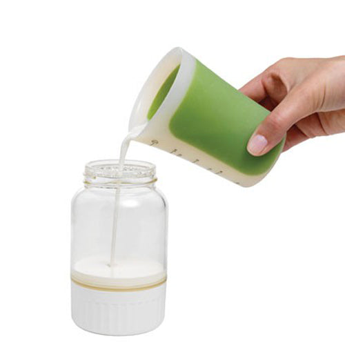 Someone is measuring cream into the butter maker.