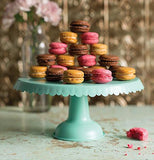 Aqua metal cake stand with a drape design with cupcakes displayed in a triangular design.