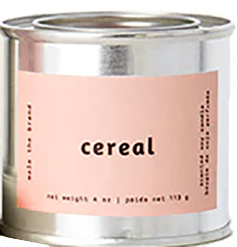 A gray tin candle-shaped can with a pastel pink label. The label says "Mala the brand--cereal--Net weight 4 oz. -- scented soy candle." There is also French text, but this alt text writer is woefully monolingual.