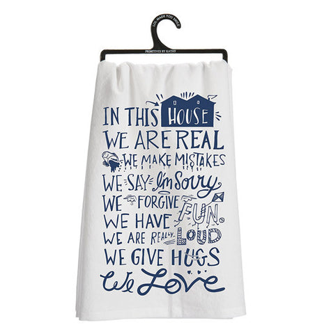 This Dish Towel has words of love in blue lettering with white background hanging on a hanger.