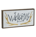 This box sign has the word, "Welcome" printed on it in navy blue lettering with antlers around it and a wooden border.