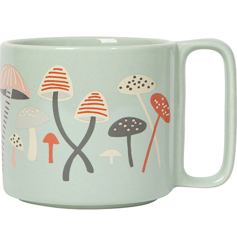 A pastel green mug with pastel orange, darker orange, pastel pink, white, and pastel grey mushrooms.