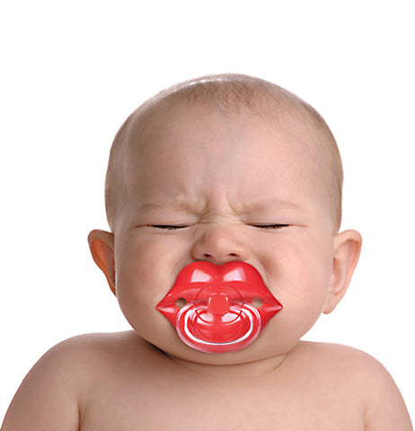 Crying baby with chill lips pacifier in his mouth calming down.