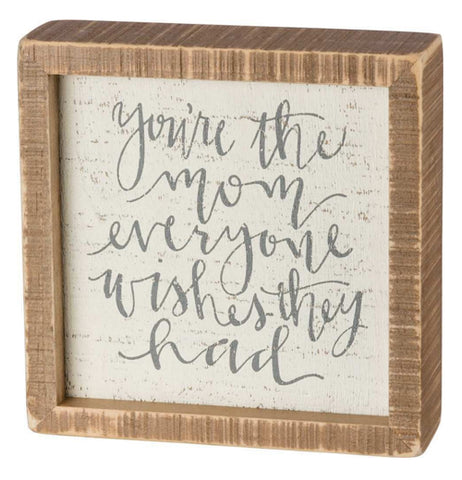 The Inset "The Mom" Box Sign has text that reads, "You're the Mom Everyone Wishes They Had" in gray words with the brown wooden frame on the outside. 