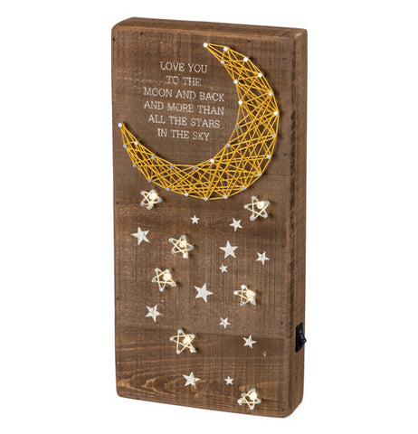 Wooden board with a moon made of pins and string as well as the stars making up a version of the peaceful night sky. It even has a "moon and back" quote printed on it.