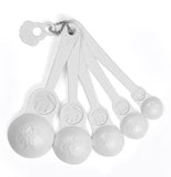 These white measuring spoons are shaped like Matryoshka dolls, ranging from greatest to smallest going from left to right.