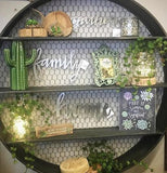 The golden letters spelling out the word, "Family" are shown hanging from the wall in the middle of a circular shelf.