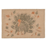 A brown placemat with a big turkey on it with different leaves.