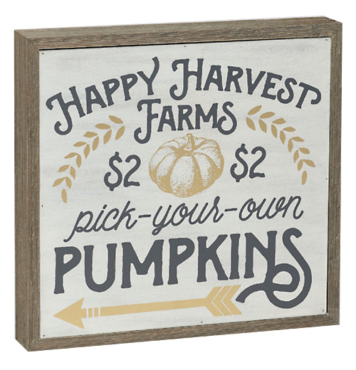 a square box sign that has "Happy Harvest Farms", Pick-Your-Own" and "Pumpkins" in different font styles with pictures of leaves, a pumpkin, and an arrow on it.
