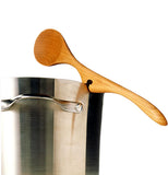 A wooden spoon with an indentation in the middle is attached to a metal pot.