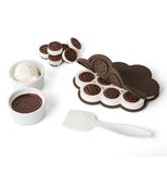 The baking dish is shown with ice cream sandwiches inside and outside it. Some dishes with cookie dough and ice cream are shown lying next to the dish and its white plastic spatula.