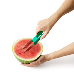The slicer's blades are shown cutting a shape into a watermelon.